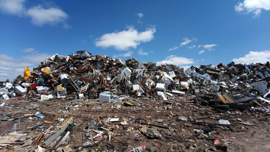 A pile of rubbish sitting on top of a dirt field