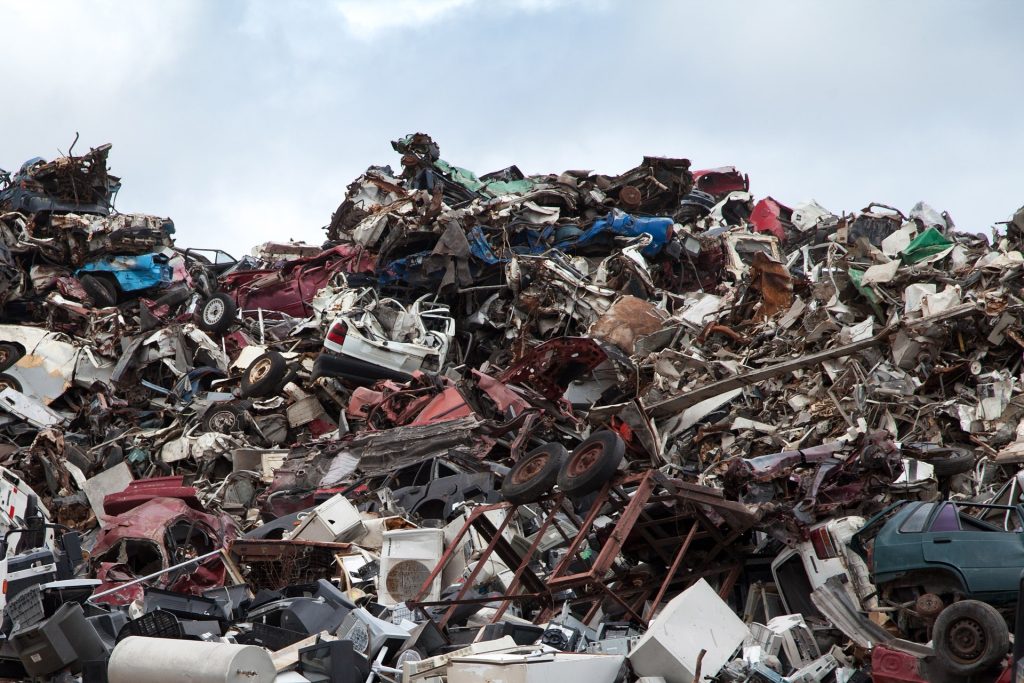 A large pile of scrap metal in a field.