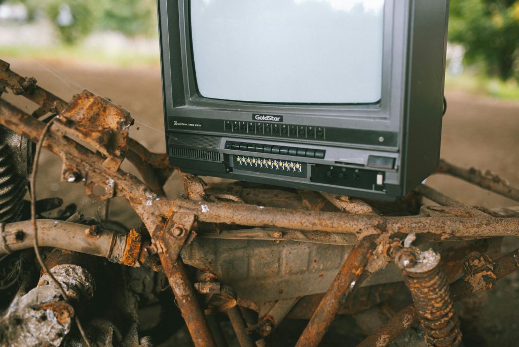 An old television sitting on top of a pile of rubble