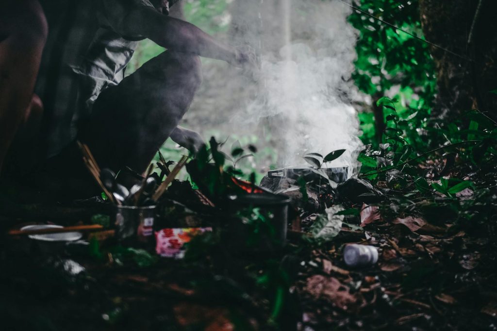 A man sitting on the ground next to a fire