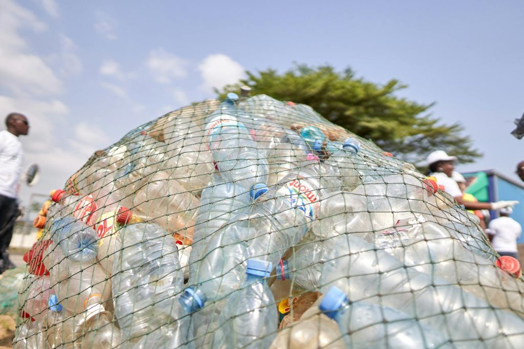 A group of men standing next to a pile of garbage